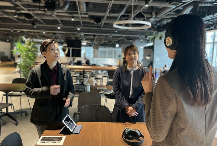 ヘッドホンを着けた受講者と講師が対話する様子